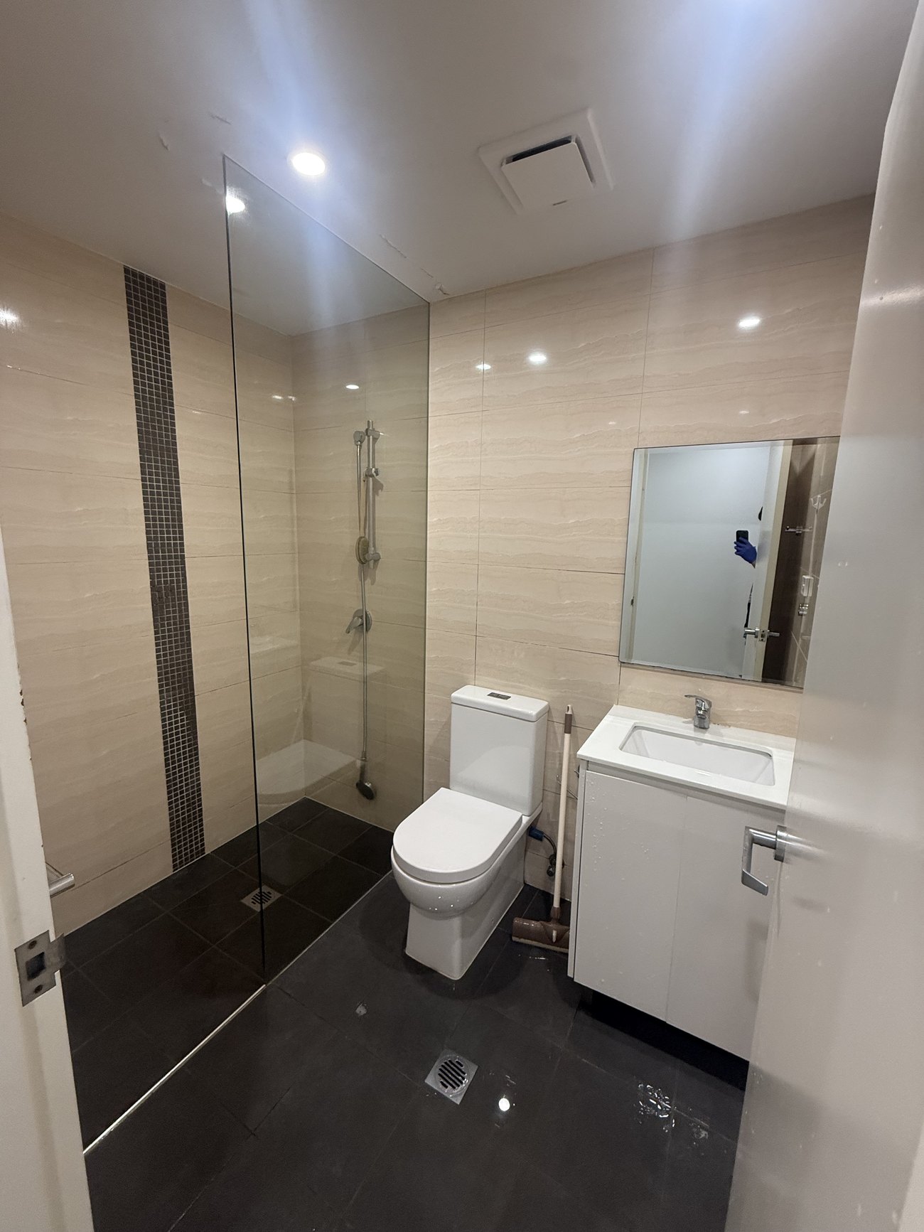Bathroom with dark tile shower and vanity cleaned